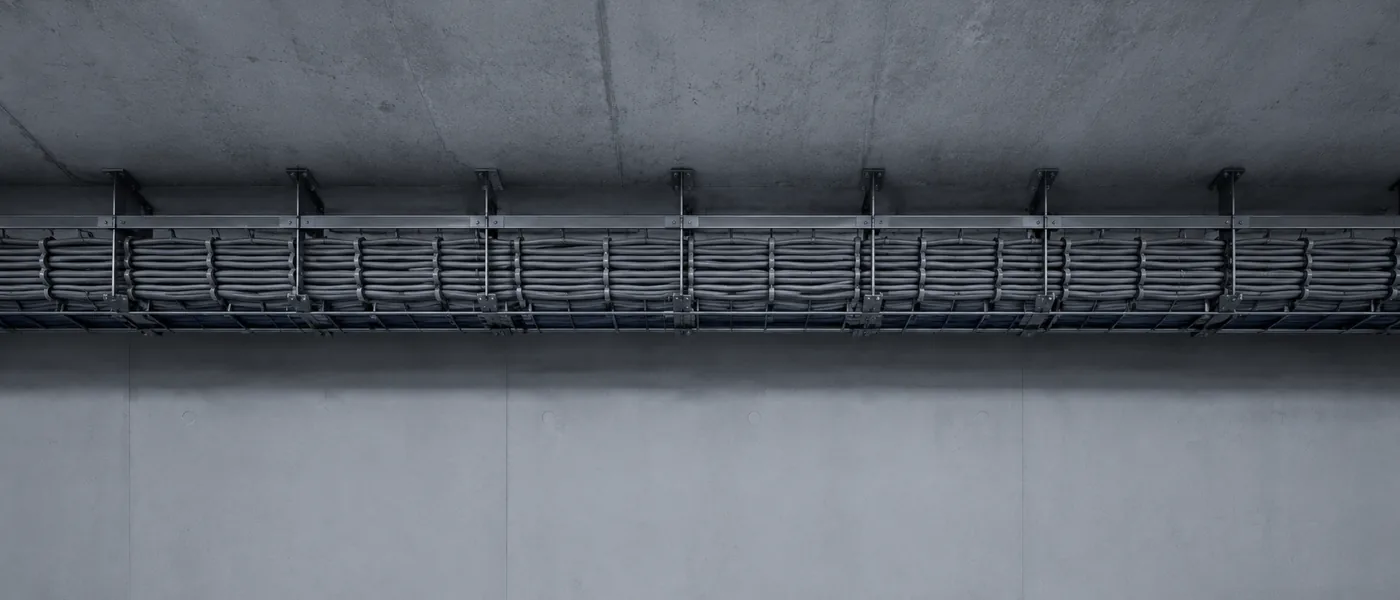 Chemin de câbles rangés courant sous un plafond de béton