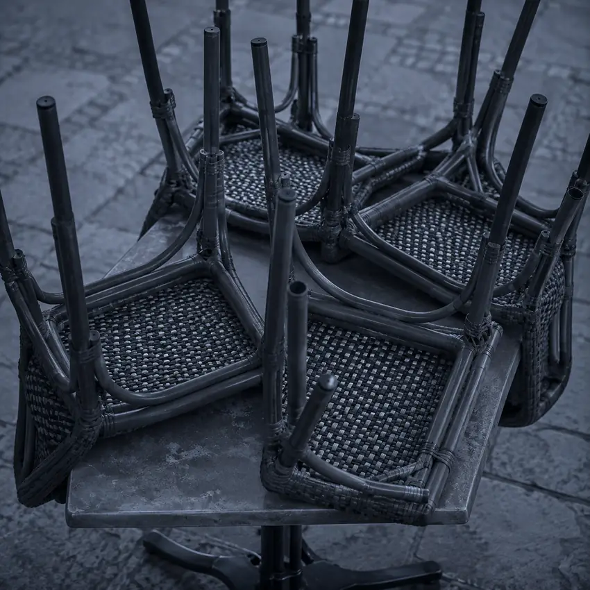 Chaises de terrasse retournées sur une table avant le service, Saint-Tropez