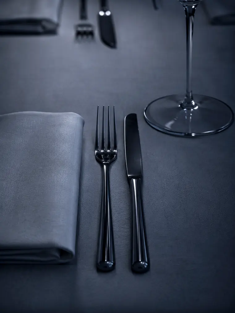 Couvert dressé sur nappe sombre, fourchette, couteau et verre — restaurant Var 83